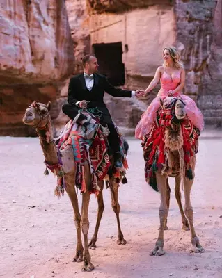 a man and a woman riding on a camel at Petra Wow Hostel in Wadi Musa