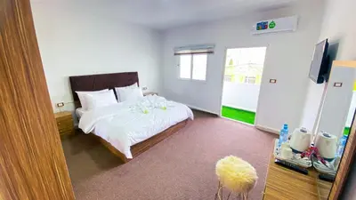 a bedroom with a bed with white sheets and a television at Petra Wow Hostel in Wadi Musa