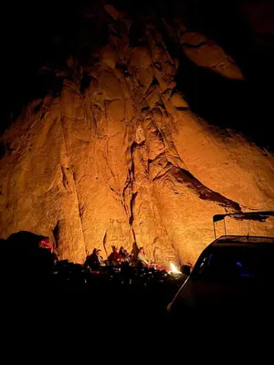 a group of people sitting in front of a cave at Wadi rum view camp in Wadi Rum