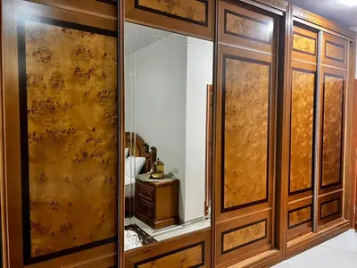 a dressing room with wooden cabinets and a mirror at Twilight Hotel Petra in Wadi Musa