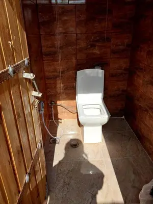 a bathroom with a toilet and a wooden wall at Feynan wild camp in Al Khuraybah
