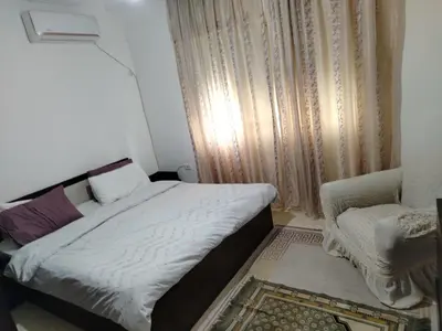 a small bedroom with a bed and a chair at شقه مفروشة الجبيهه in Amman