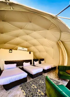 a room with three beds in a tent at Rum Darien Camp in Wadi Rum