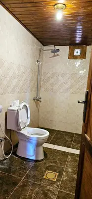 a bathroom with a toilet with the lid up at Rum Darien Camp in Wadi Rum