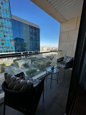 a balcony with chairs and a view of a building at Downtown pearl Amman in Amman