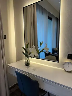 a mirror on a counter with a vase of flowers at Downtown pearl Amman in Amman