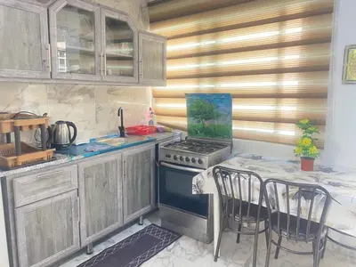 a kitchen with a stove and a table with chairs at شقه بغرفه وصاله وبلكونه بدون شراكة in Amman