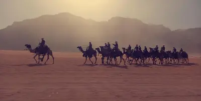 a group of people riding horses in the desert at blueskyrum. in Wadi Rum