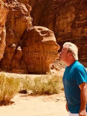 a man standing in front of a canyon at blueskyrum. in Wadi Rum