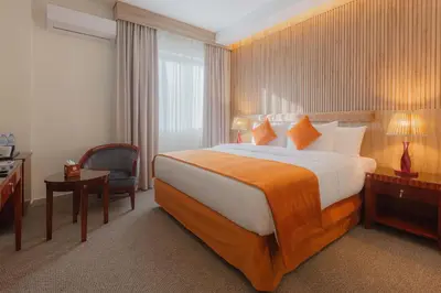 a hotel room with a large bed and a chair at Amman Inn Boutique Hotel in Amman