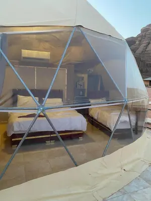 a tent with two beds in a room at Yara camp in Wadi Rum