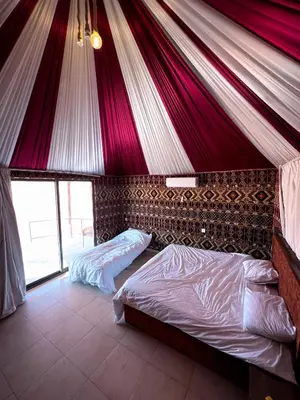 a tent with two beds in a bedroom at Natalie Wadi Rum camp in Wadi Rum