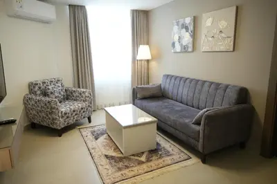 a living room with a couch and a chair at Red Carpet Hotel & Suites in Amman