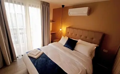 a bedroom with a bed with pillows and a window at Red Carpet Hotel & Suites in Amman