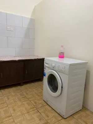 a washing machine with a bottle on top of it at Central house with beautiful garden in Amman