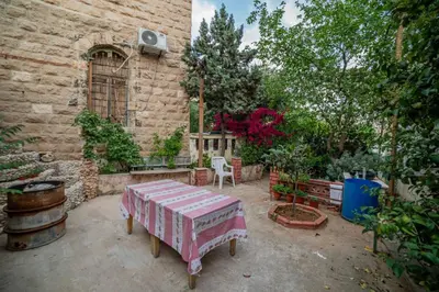 a patio with a table and some plants and a building at Central house with beautiful garden in Amman