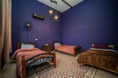 a bedroom with two beds and a purple wall at Central house with beautiful garden in Amman