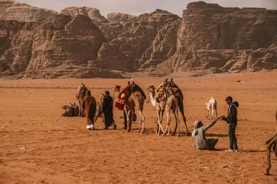a group of people with camels in the desert at Desert Star of Wadi Rum in Wadi Rum