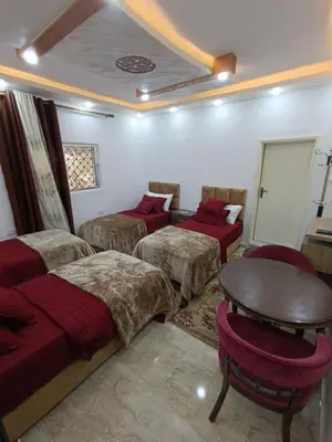 a room with three beds and a table at Petra downtown house in Wadi Musa