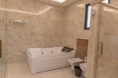 a bathroom with a tub and a toilet and a sink at Adam's Luxury Villa DeadSea in Sowayma