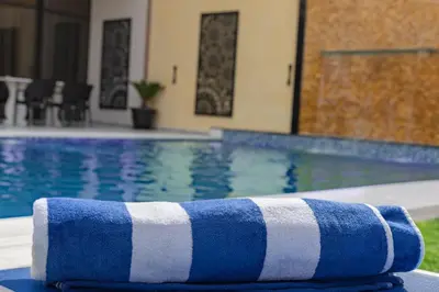 a blue and white towel sitting next to a swimming pool at Adam's Luxury Villa DeadSea in Sowayma