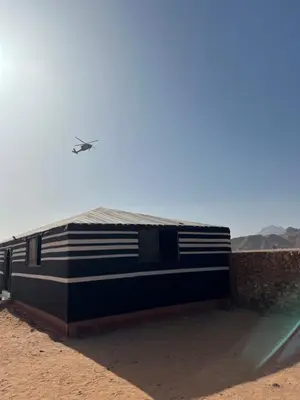 a plane flying over a building in the desert at Al-Shakriya Village Camp in Wadi Rum