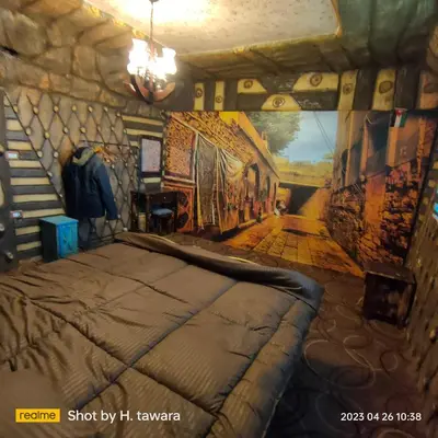 a bedroom with a bed and a painting on the wall at Petra Dad Farm (PDF) in Umm Şawwānah