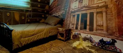 a room with a bed and a painting on the wall at Petra Dad Farm (PDF) in Umm Şawwānah