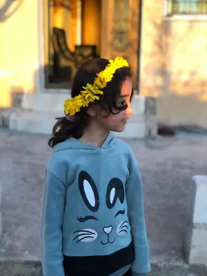 a young girl wearing a blue shirt with a cat on it at Pasha's house in Balad al Manşūrah