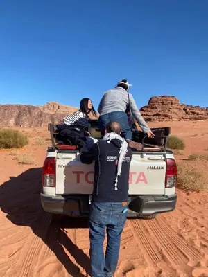 a group of people in the back of a truck in the desert at Rayyan Bedouin life camp in Wadi Rum