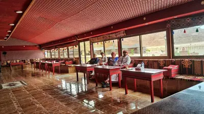 three people sitting at tables in a restaurant at Rayyan Bedouin life camp in Wadi Rum
