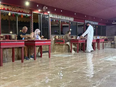 a group of people sitting at tables in a restaurant at Rayyan Bedouin life camp in Wadi Rum