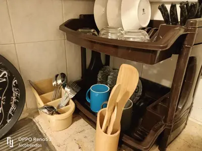 a kitchen counter with a shelf with utensils at Plaza de petra in Wadi Musa