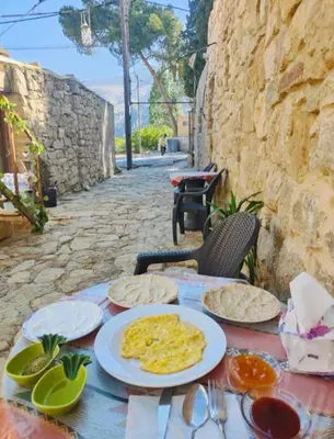 a table with plates of food on top of it at Dana Sunset Village Hotel in Dana
