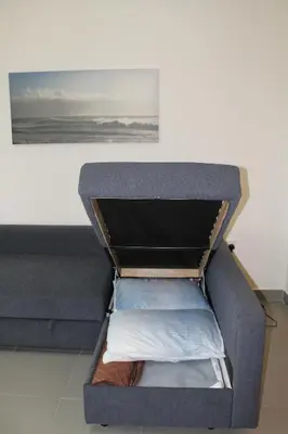 an open box with clothes inside of a couch at Samarah Dead Sea Resort Apartment with Sea View FP4 Traveler Award 2025 Winner Thursday, Friday & Saturday Groups consisting solely of male guests are not permitted in Sowayma