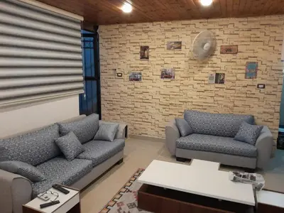 a living room with two couches and a brick wall at MK2 - One Bedroom Apartment in Amman