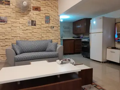 a living room with a couch and a kitchen at MK2 - One Bedroom Apartment in Amman