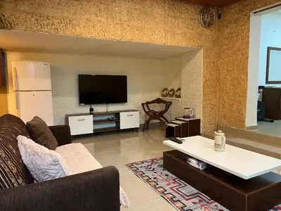 a living room with a couch and a flat screen tv at MK2 - One Bedroom Apartment in Amman