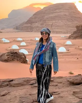 a woman standing on a rock in the desert at Wadi Rum The ARC camp in Wadi Rum