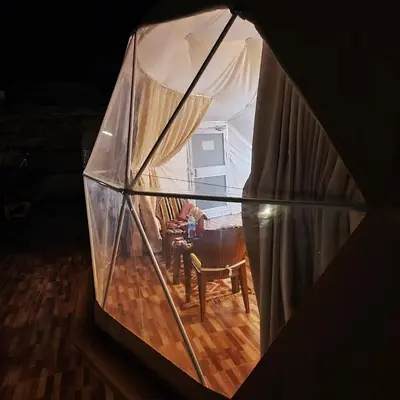 a glass dome with a person sitting in a chair in a room at Wadi Rum Calma camp in Aqaba