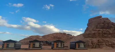 a row of houses in front of a mountain at Wadi Rum Calma camp in Aqaba
