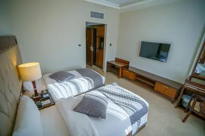 a hotel room with two beds and a flat screen tv at Petra Icon Hotel in Wadi Musa