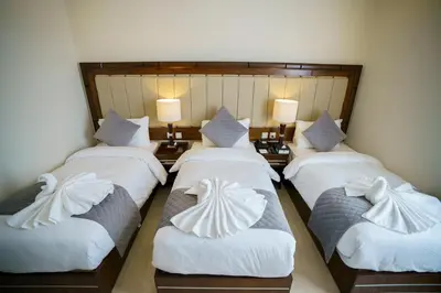 a group of four beds in a room at Petra Icon Hotel in Wadi Musa