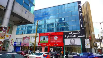a busy city street with cars parked in front of buildings at Sorate Hotel Apartment in Amman