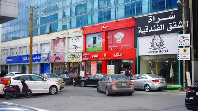 a busy city street with cars parked in front of buildings at Sorate Hotel Apartment in Amman