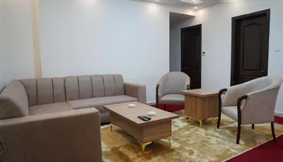 a living room with a couch and chairs and a table at Sorate Hotel Apartment in Amman