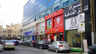 a city street with cars parked in front of buildings at Sorate Hotel Apartment in Amman