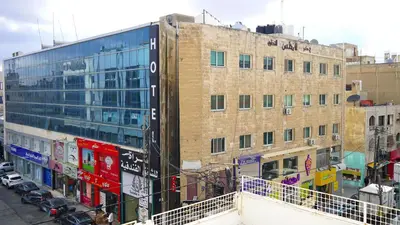 a tall brick building with graffiti on the side of it at Sorate Hotel Apartment in Amman