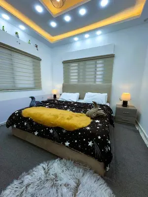 a bedroom with a large bed with a yellow blanket at Jerash City View in Jerash