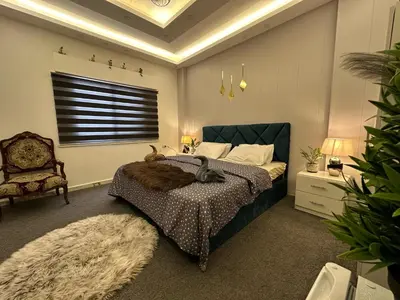 a bedroom with a bed and a chair and a window at Jerash City View in Jerash